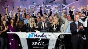 La présidente de SpaceX, Gwynne Shotwell, et le président des acquisitions stratégiques de l’entreprise, Bret Johnsen, sont rejoints par la direction de la société alors qu'ils sonnent la cloche d'ouverture pour célébrer l’IPO de SpaceX vendredi.